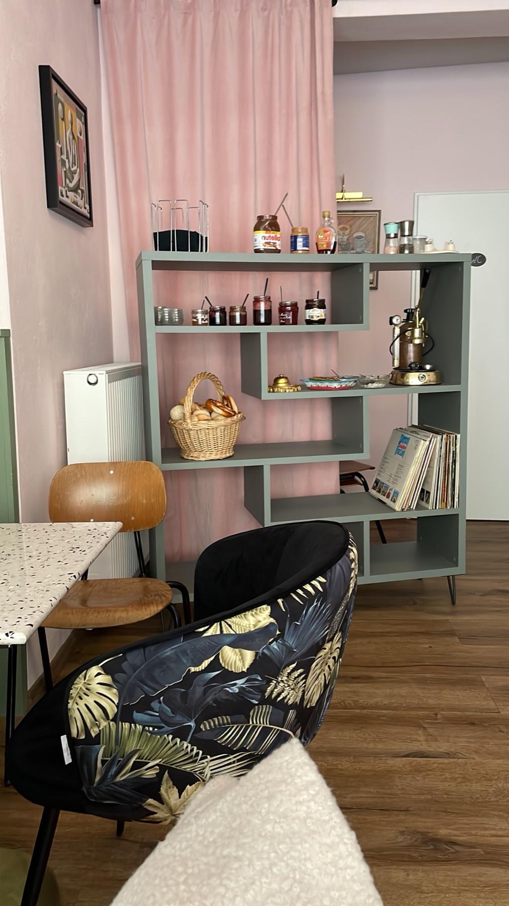 Regal-Ecke mit rosa Vorhang, Marmeladen und Espressokanne