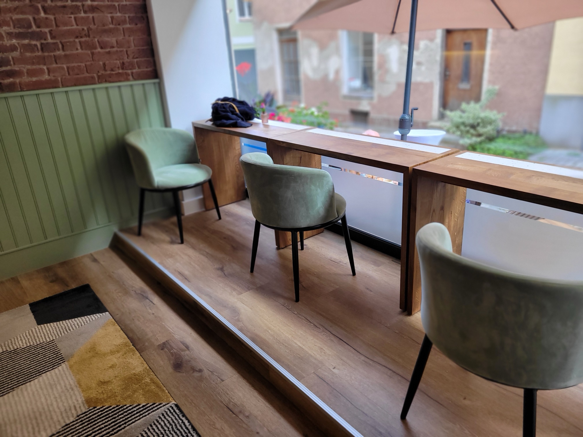 Fensterbar mit salbeigrünen Samtstühlen und Blick in die Donaugasse